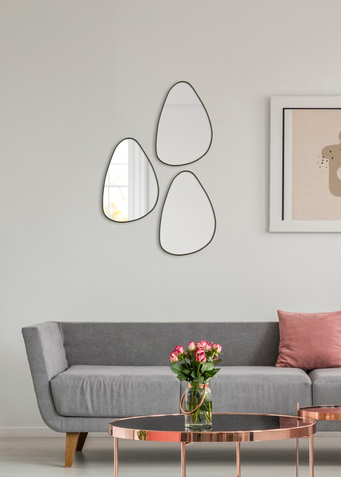 Drie organisch gevormde wandspiegels in een moderne woonkamer, gezien van voren.