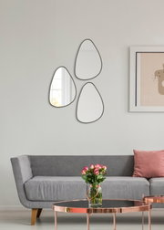 Drie organisch gevormde wandspiegels in een moderne woonkamer, gezien van voren.