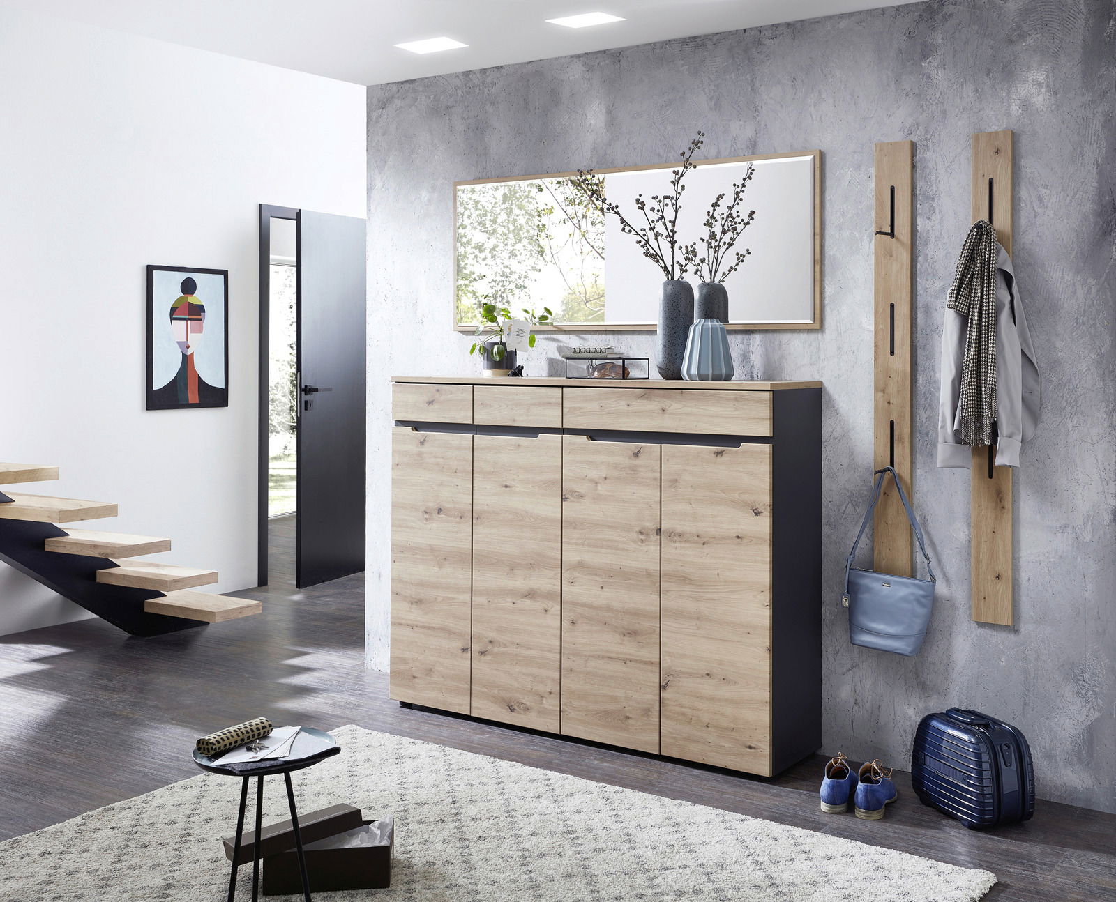 Moderner Eingangsbereich mit einem XL-Schuhschrank in Holzoptik, flankiert von zwei Garderobenpaneelen. Perspektive von vorne.