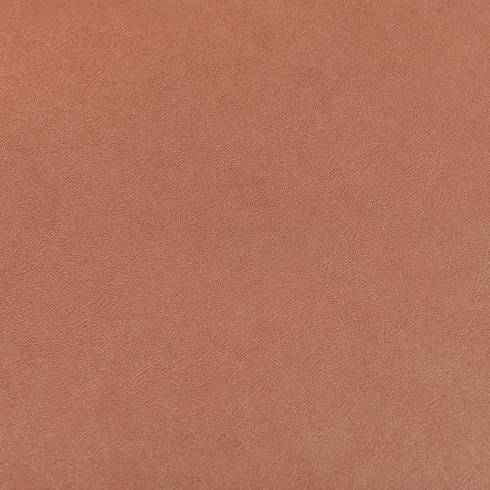 Nahaufnahme einer orangefarbenen, strukturierten Oberfläche eines Stuhlsitzes.