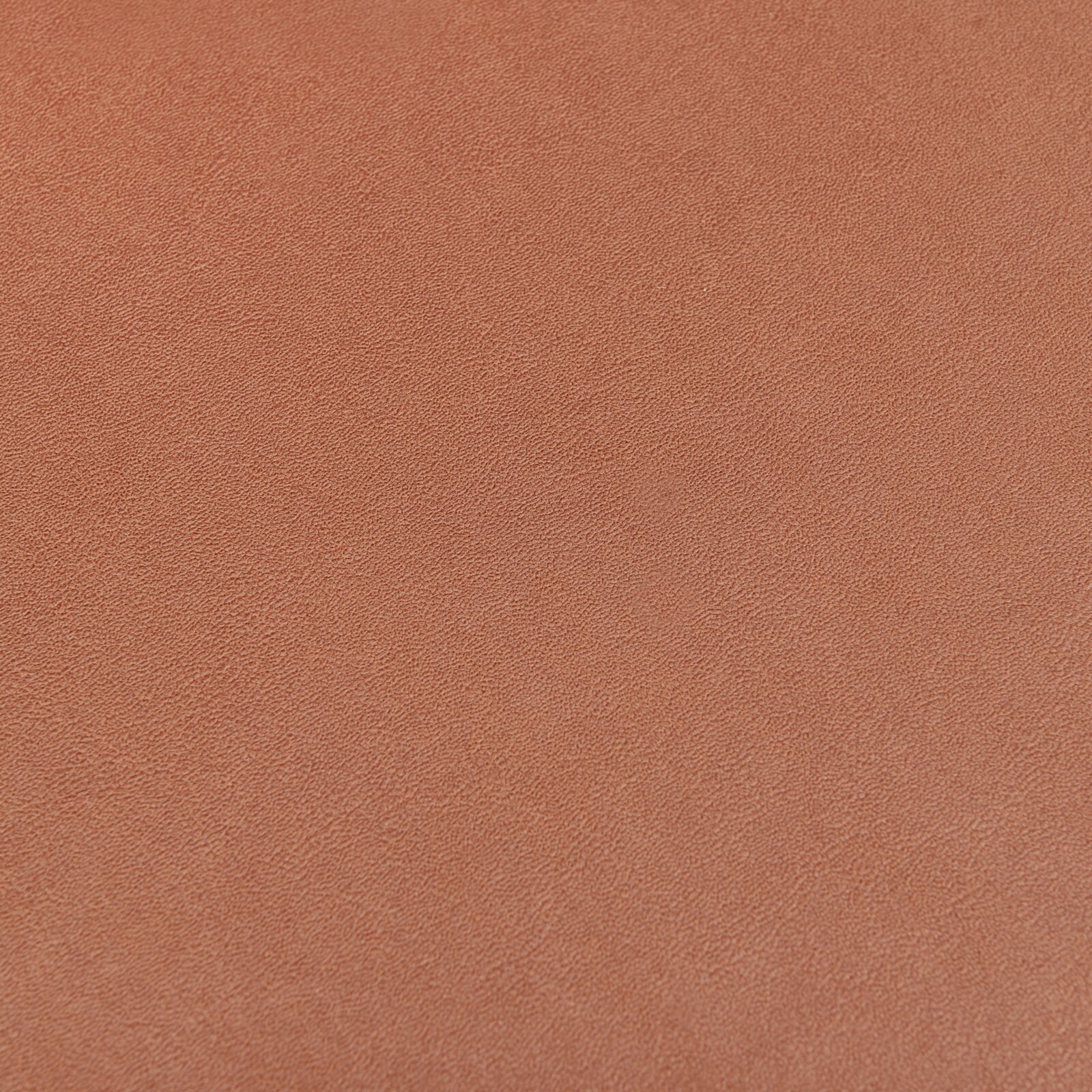 Nahaufnahme einer orangefarbenen, strukturierten Oberfläche eines Stuhlsitzes.