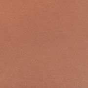 Nahaufnahme einer orangefarbenen, strukturierten Oberfläche eines Stuhlsitzes.