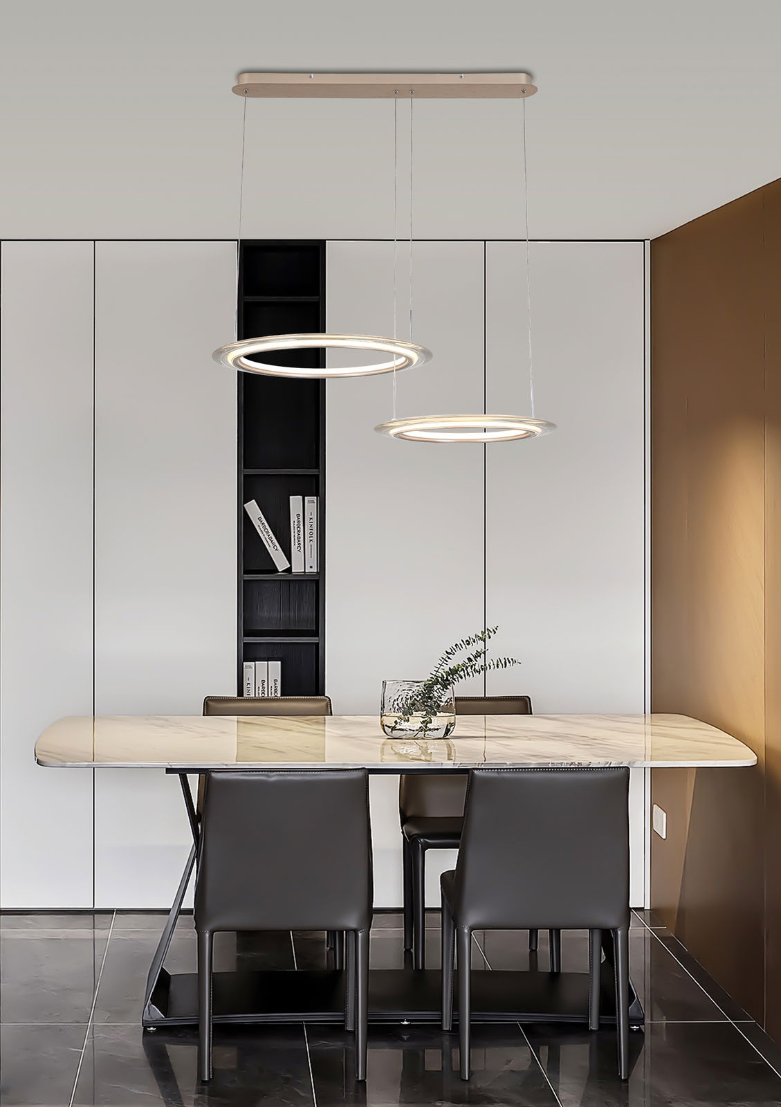 Moderne LED-Hängeleuchte mit zwei leuchtenden Ringen über einem Esstisch, seitliche Perspektive.