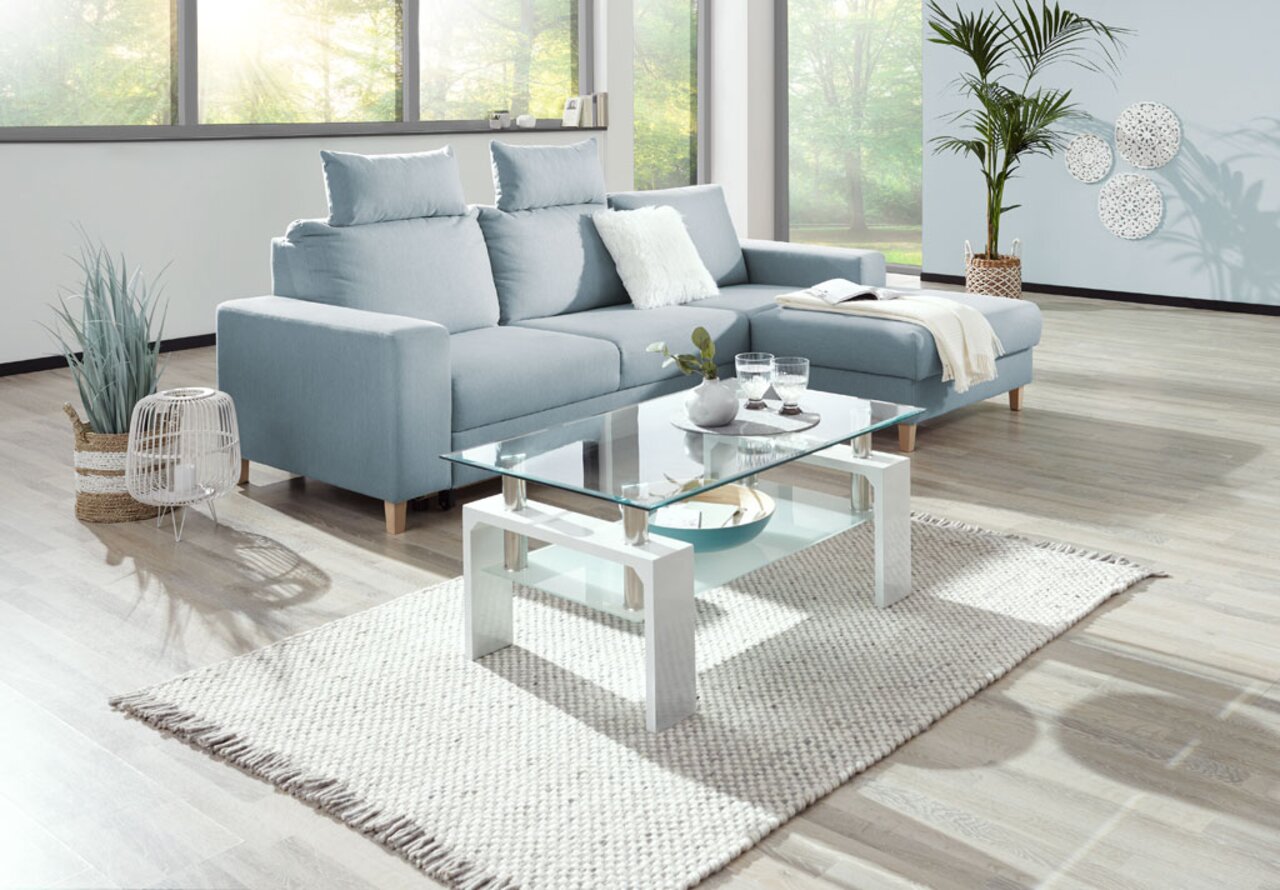 Z2 Couchtisch SANDY Moderner Couchtisch mit Glasplatte und weißen Beinen, fotografiert aus einer leicht erhöhten Perspektive in einem hellen Wohnzimmer.