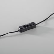 Nahaufnahme eines schwarzen Kippschalters an einem Kabel, perspektivisch von oben fotografiert.