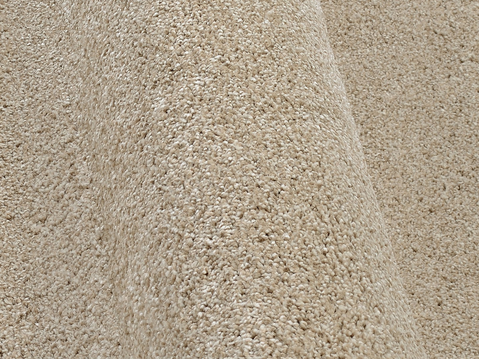Nahaufnahme eines beigen Uni-Teppichs mit weicher Textur, seitliche Perspektive