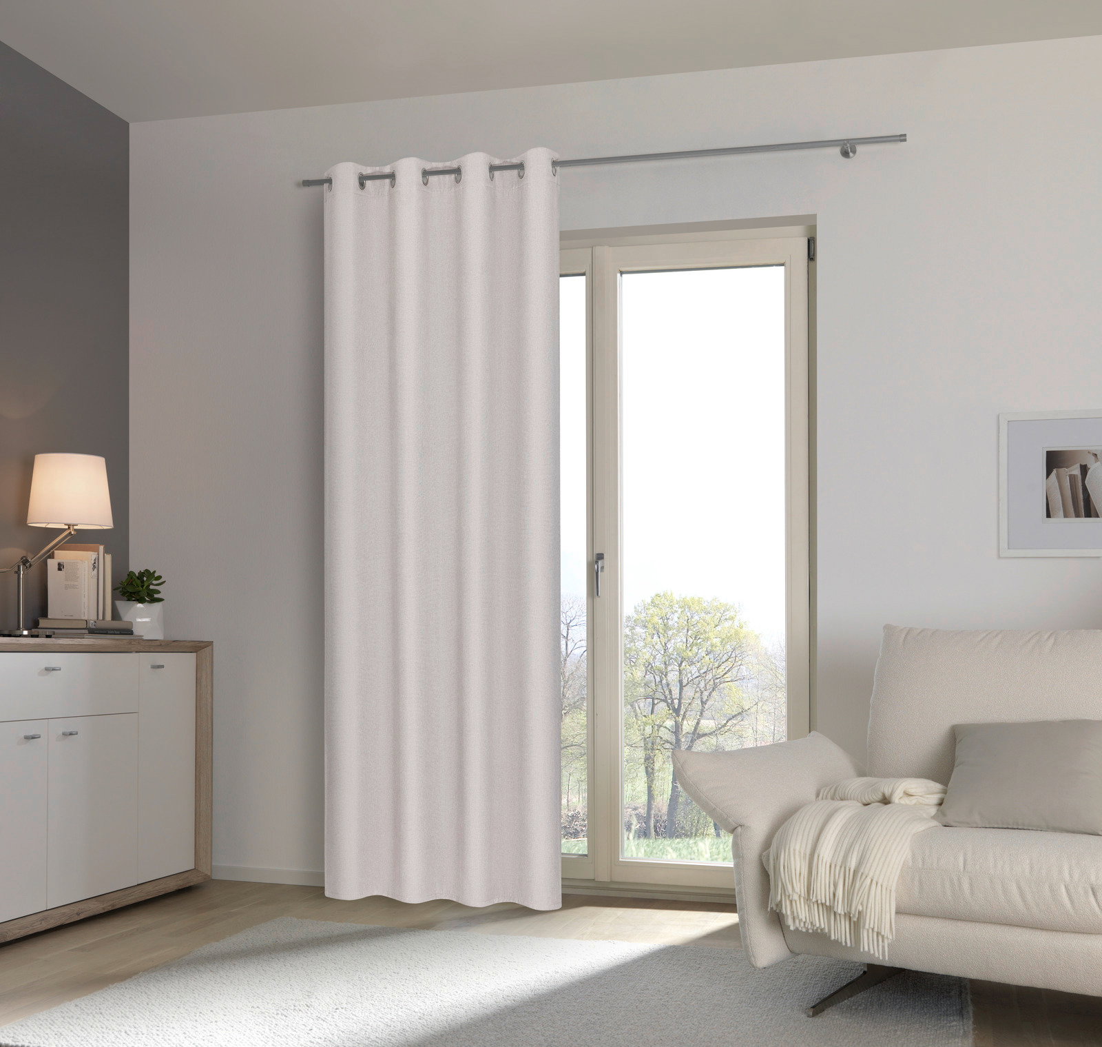 Heller Ösenschal vor einem Fenster in einem modernen Wohnzimmer, seitliche Perspektive