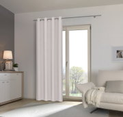 Heller Ösenschal vor einem Fenster in einem modernen Wohnzimmer, seitliche Perspektive