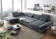 Großes, graues Ecksofa in einem modernen Wohnzimmer mit Blick auf die Stadt durch große Fenster. Perspektive von schräg oben.