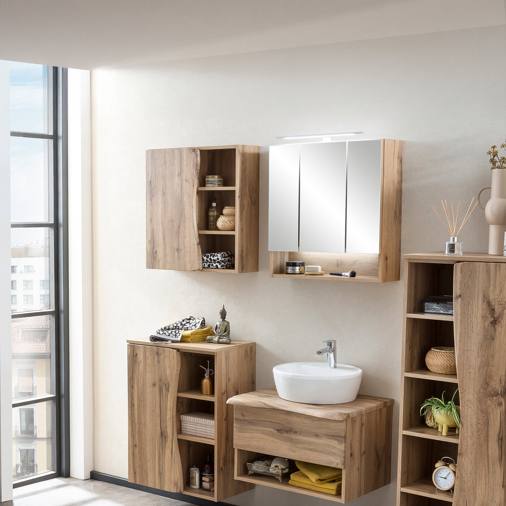 Modernes Bad mit Holzoptik-Möbeln, Spiegelschrank, Waschbecken und offenen Regalen.