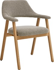 Gepolsterter Esszimmerstuhl mit grauem Bouclé-Bezug, geschwungener Rückenlehne und Armlehnen sowie Holzgestell in Eiche-Optik, freigestellt auf weißem Hintergrund, Ansicht schräg von vorne.