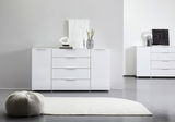 Weißes Sideboard mit drei Schubladen und zwei Türen, dekoriert mit modernen Accessoires, aus frontaler Perspektive fotografiert.
