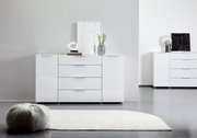 Weißes Sideboard mit drei Schubladen und zwei Türen, dekoriert mit modernen Accessoires, aus frontaler Perspektive fotografiert.