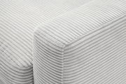 Nahaufnahme einer hellgrauen, gerippten Stoffoberfläche eines Longchairs, perspektivisch von oben fotografiert.
