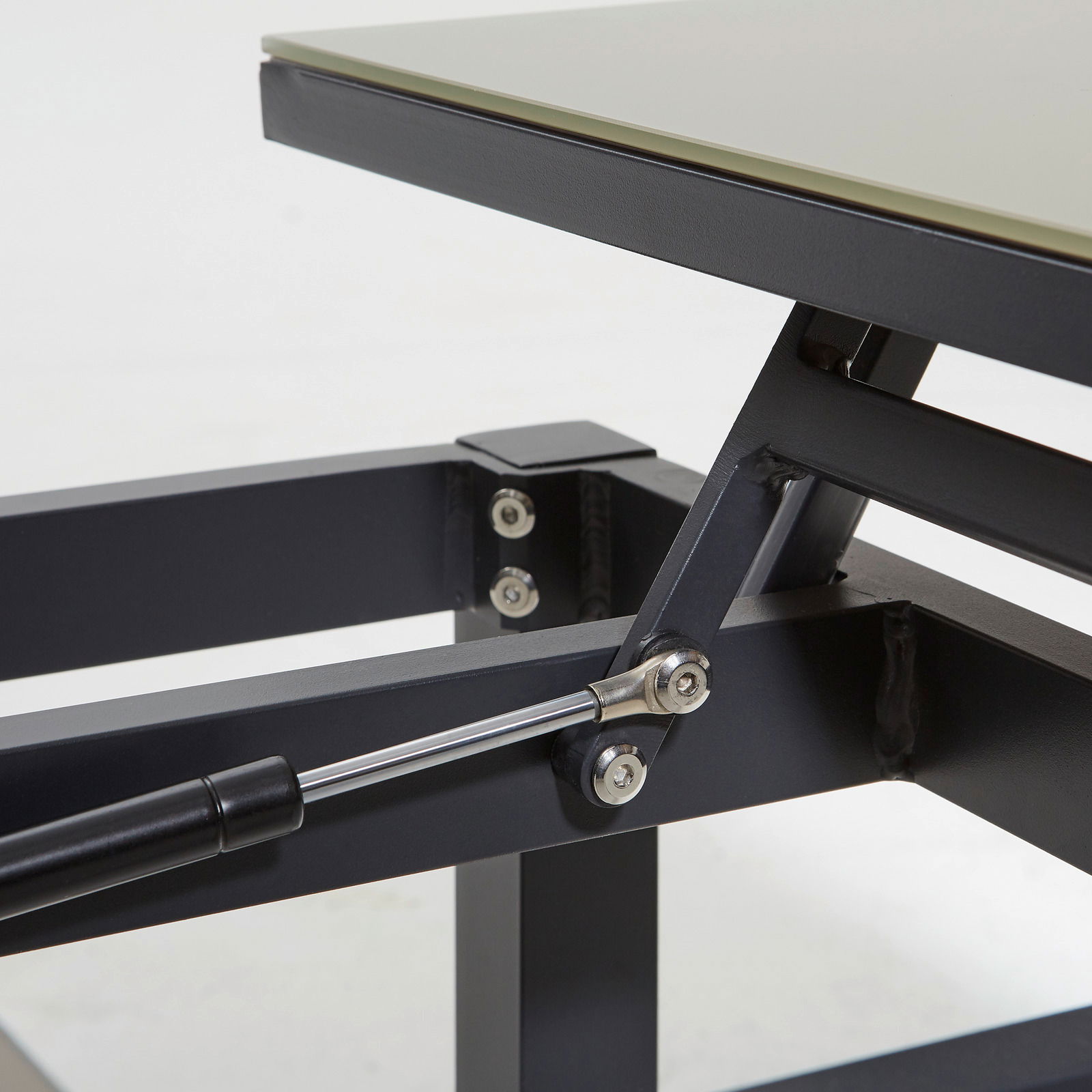 Nahaufnahme eines Loungetischs mit Metallgestell und Hebemechanismus, seitliche Perspektive.
