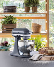 Küchenmaschine 4,3l in einer modernen Küche, seitliche Perspektive, mit frischem Brot und Pflanzen im Hintergrund.