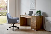 Moderner Schreibtisch aus Holz mit Schubladen und Lamellen-Design, seitliche Perspektive, neben einem Fenster mit Blick ins Grüne.