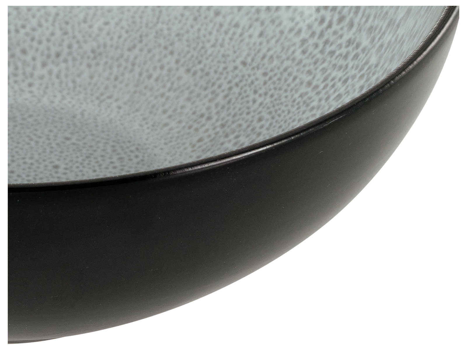 Nahaufnahme eines schwarzen Tellers mit grauer, gesprenkelter Innenseite, seitliche Perspektive