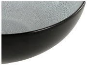 Nahaufnahme eines schwarzen Tellers mit grauer, gesprenkelter Innenseite, seitliche Perspektive