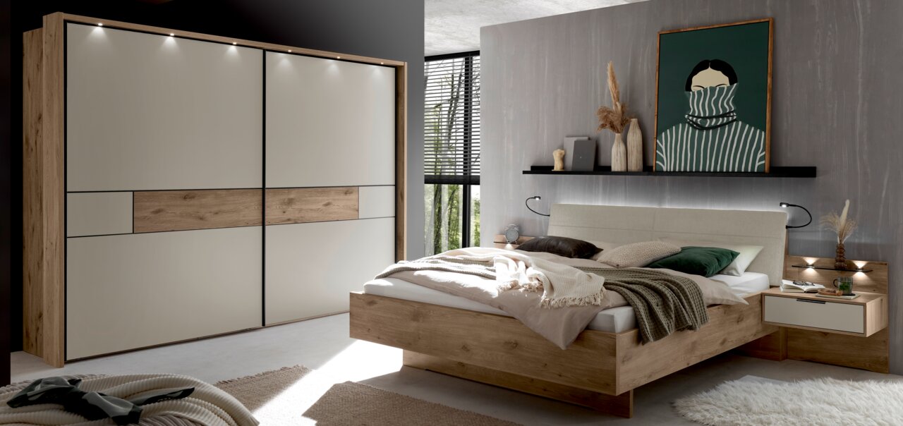 Venda Hangende kast met 2 deuren VILLACH Moderne slaapkamerset met een grote kast met zweefdeuren in hout- en crèmekleurige afwerking, aangevuld met een bijpassend bed en nachtkastje, gefotografeerd vanuit een schuin vooraanzicht.