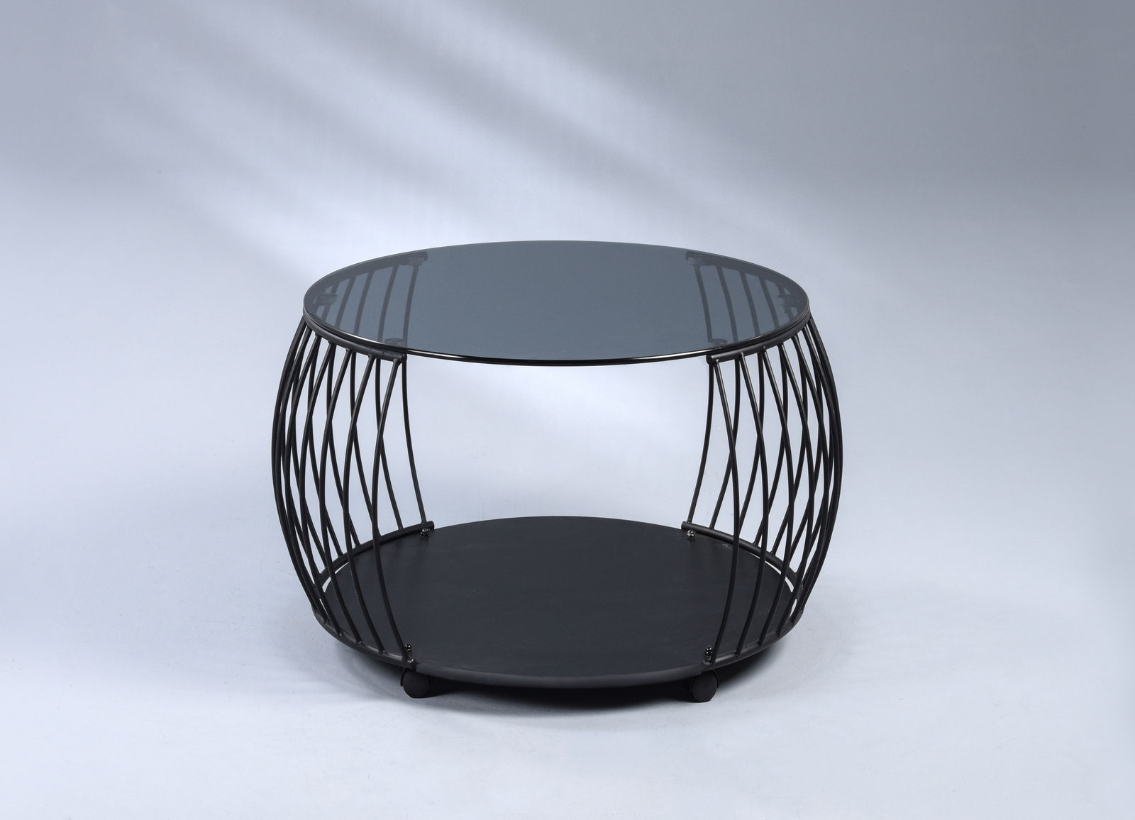 Moderner Couchtisch mit rundem Glasplatte und schwarzem Metallgestell, seitliche Perspektive