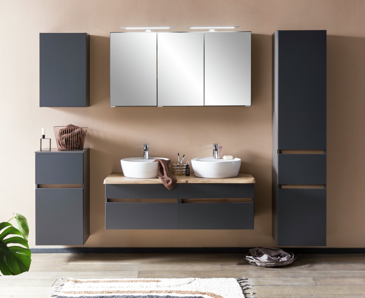 Moderner Badezimmer-Hängeschrank in dunklem Grau, frontal fotografiert, Teil eines stilvollen Badezimmersetups mit Waschbecken und Spiegel.