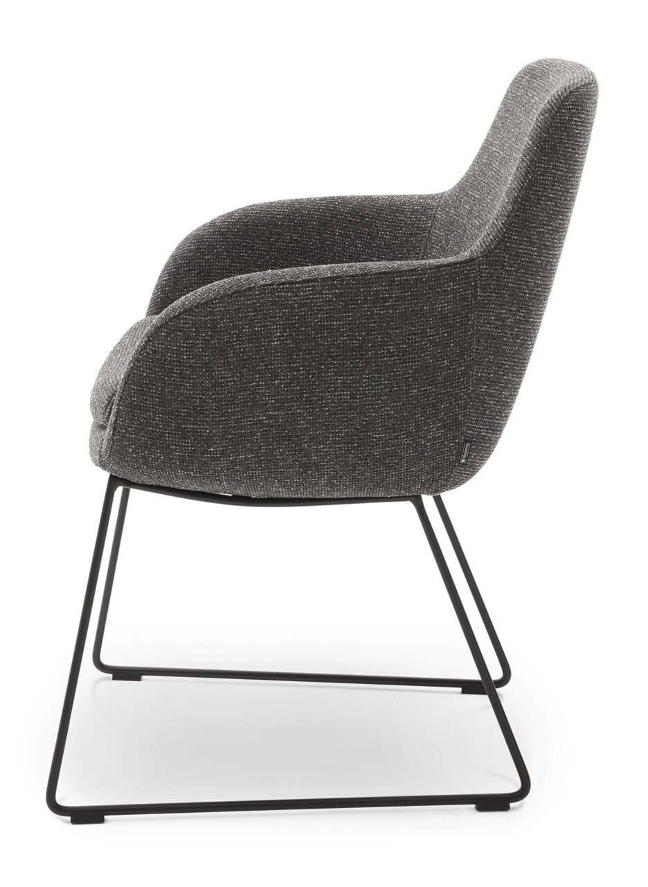 Zijaanzicht van een moderne fauteuil met grijze stoffen bekleding en een zwart metalen frame.