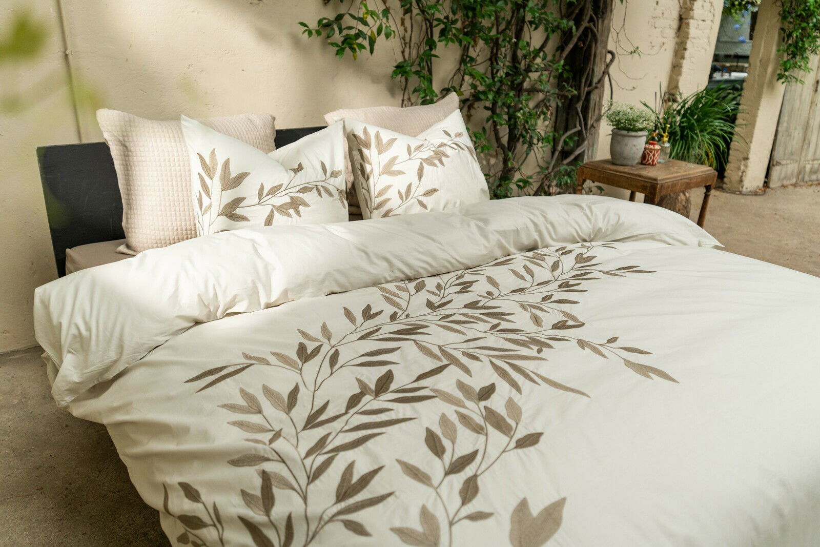 Bettwäsche-Set mit Blattmuster in einem gemütlichen Raum, seitliche Perspektive