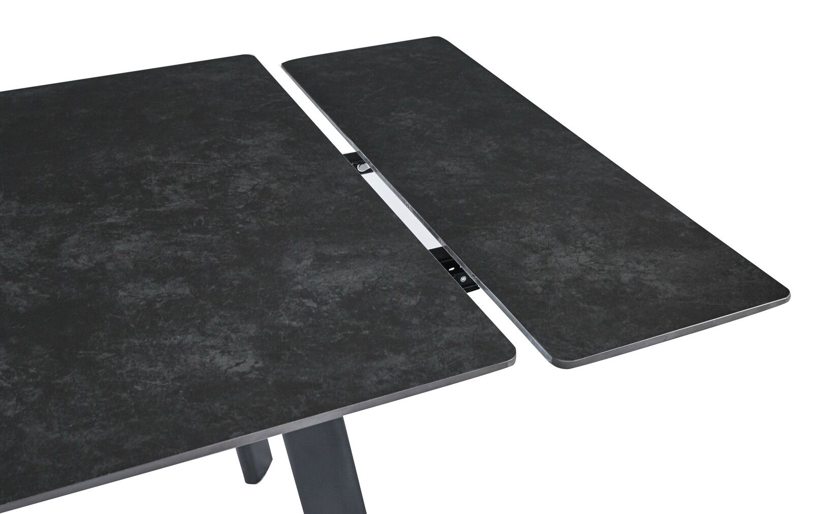 Nahaufnahme eines ausziehbaren Esstisches mit dunkler, steinartiger Oberfläche und Metallmechanismus.