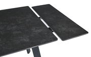 Nahaufnahme eines ausziehbaren Esstisches mit dunkler, steinartiger Oberfläche und Metallmechanismus.