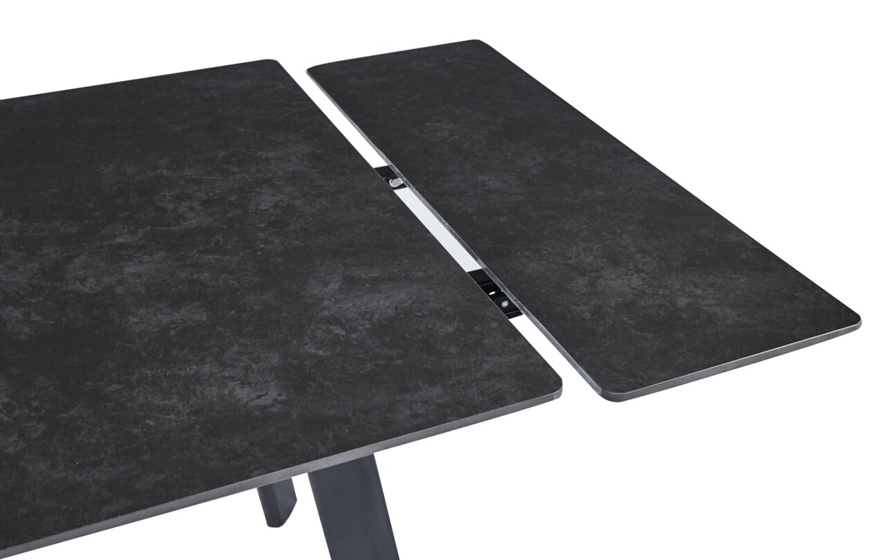 Close-up van een uitschuifbare eettafel met een donker, steenachtig oppervlak en een metalen mechanisme.