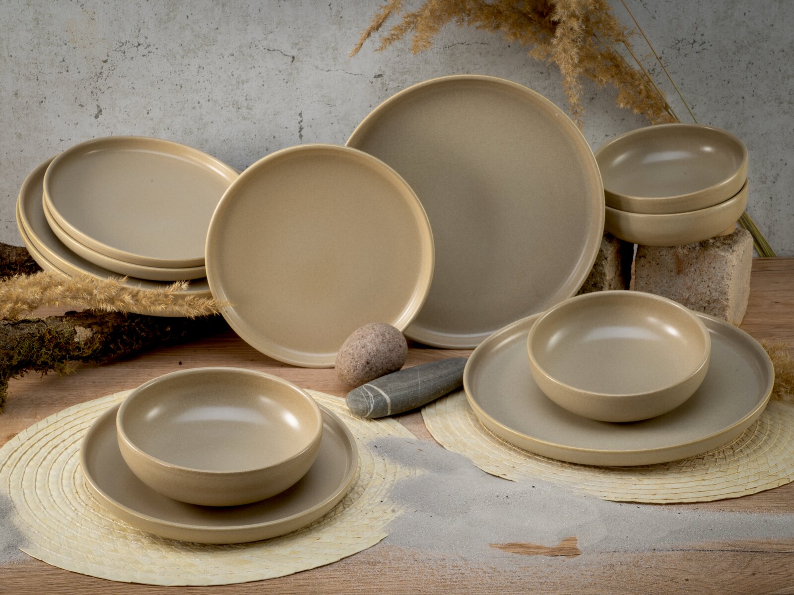 Beige Tellerset 12-tlg in rustikalem Design, frontal und seitlich präsentiert auf einem Holztisch mit natürlicher Dekoration.