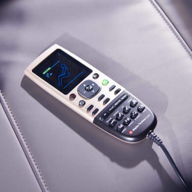 Fernbedienung eines Massagesessels auf einer Lederoberfläche, von oben fotografiert.