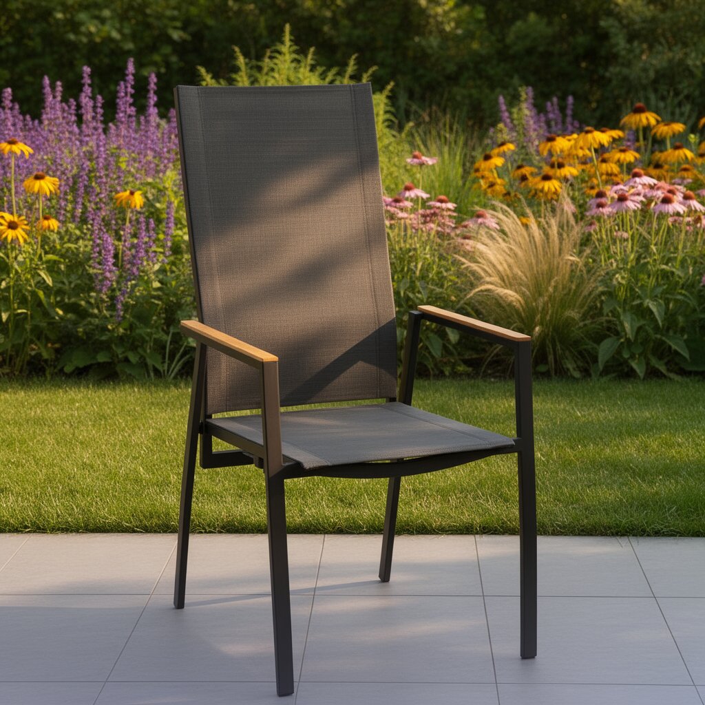 Amatio Tuinstoel CHUR Moderne tuin- en terrasstoel met zwart metalen frame, grijze textileen zitting en rugleuning en armleuningen met houtlook, gefotografeerd in een 3/4 vooraanzicht op een terras met bloeiende tuin op de achtergrond