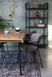 Grauer Armlehnenstuhl an einem Holztisch, seitliche Perspektive