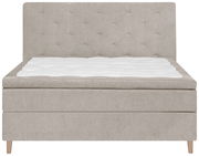 Frontale Ansicht eines beigen Boxspringbetts mit gestepptem Kopfteil und weißer Matratzenauflage.
