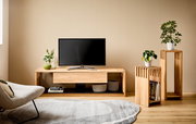 Holz-TV-Lowboard mit Pflanzen und Dekorationen, seitliche Perspektive