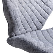 Nahaufnahme eines grauen, gepolsterten Drehstuhls mit gestepptem Stoffbezug, seitliche Perspektive