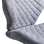 Close-up van een grijze, gestoffeerde draaistoel met doorgestikte stoffen bekleding, gezien vanaf de zijkant