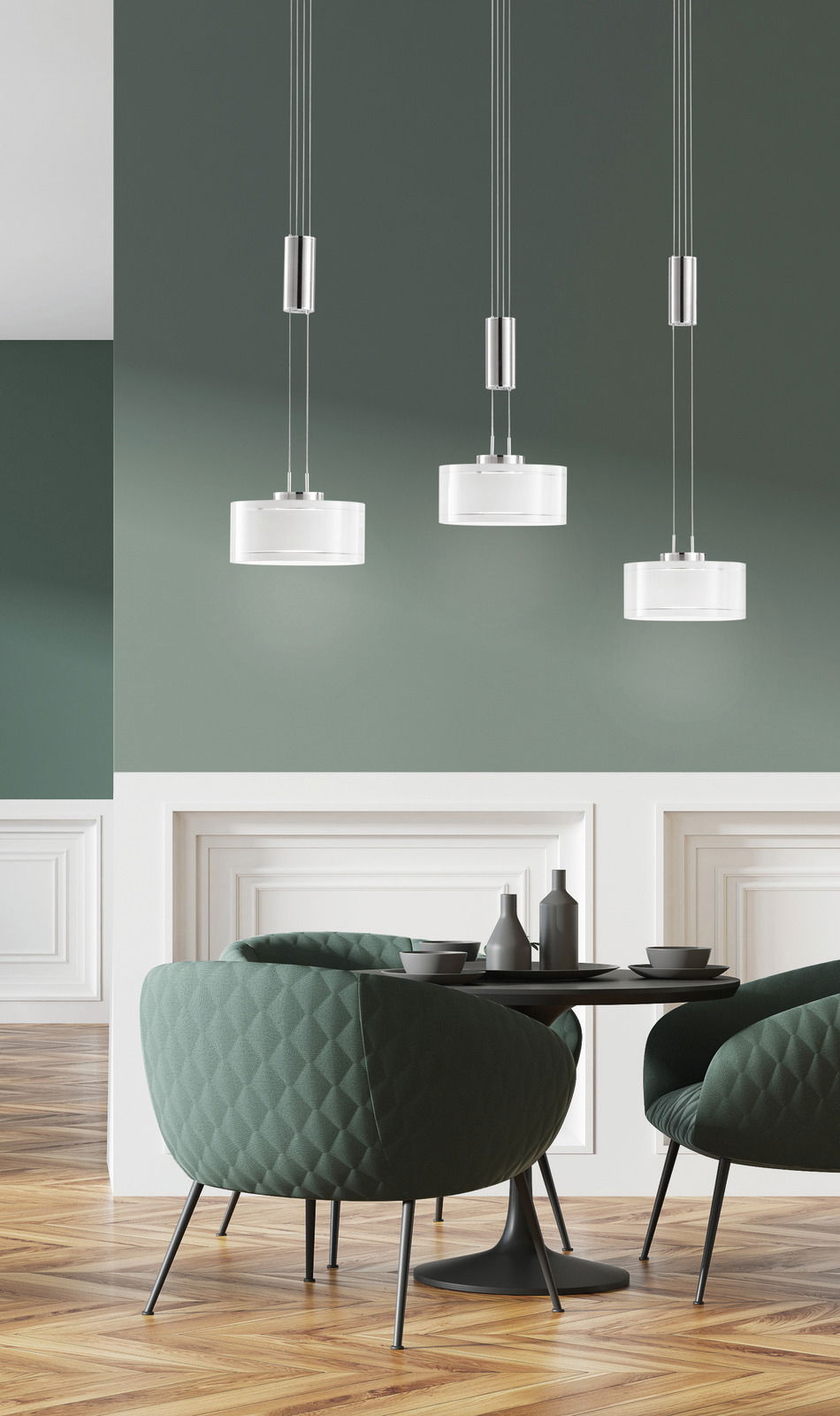 Moderne LED-Pendelleuchte mit drei Leuchten, hängend über einem stilvollen Essbereich mit grünen Sesseln und einem runden Tisch, seitliche Perspektive.
