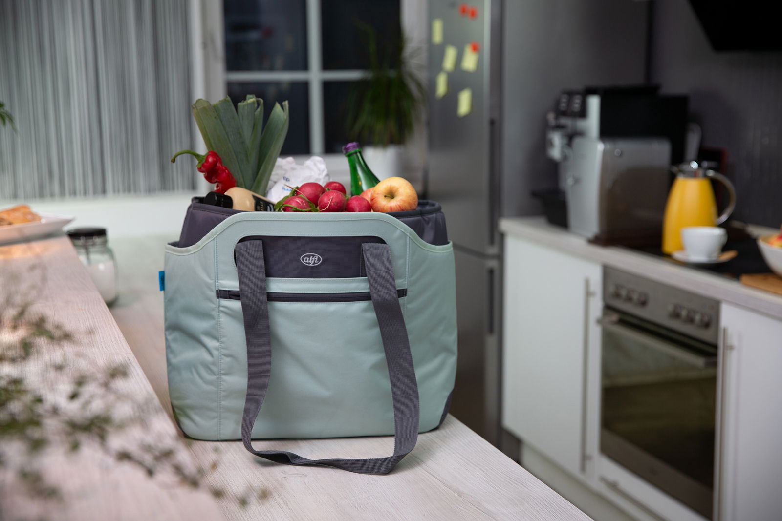 Iso Bag in einer Küche, gefüllt mit frischem Obst und Gemüse, aus einer seitlichen Perspektive fotografiert.