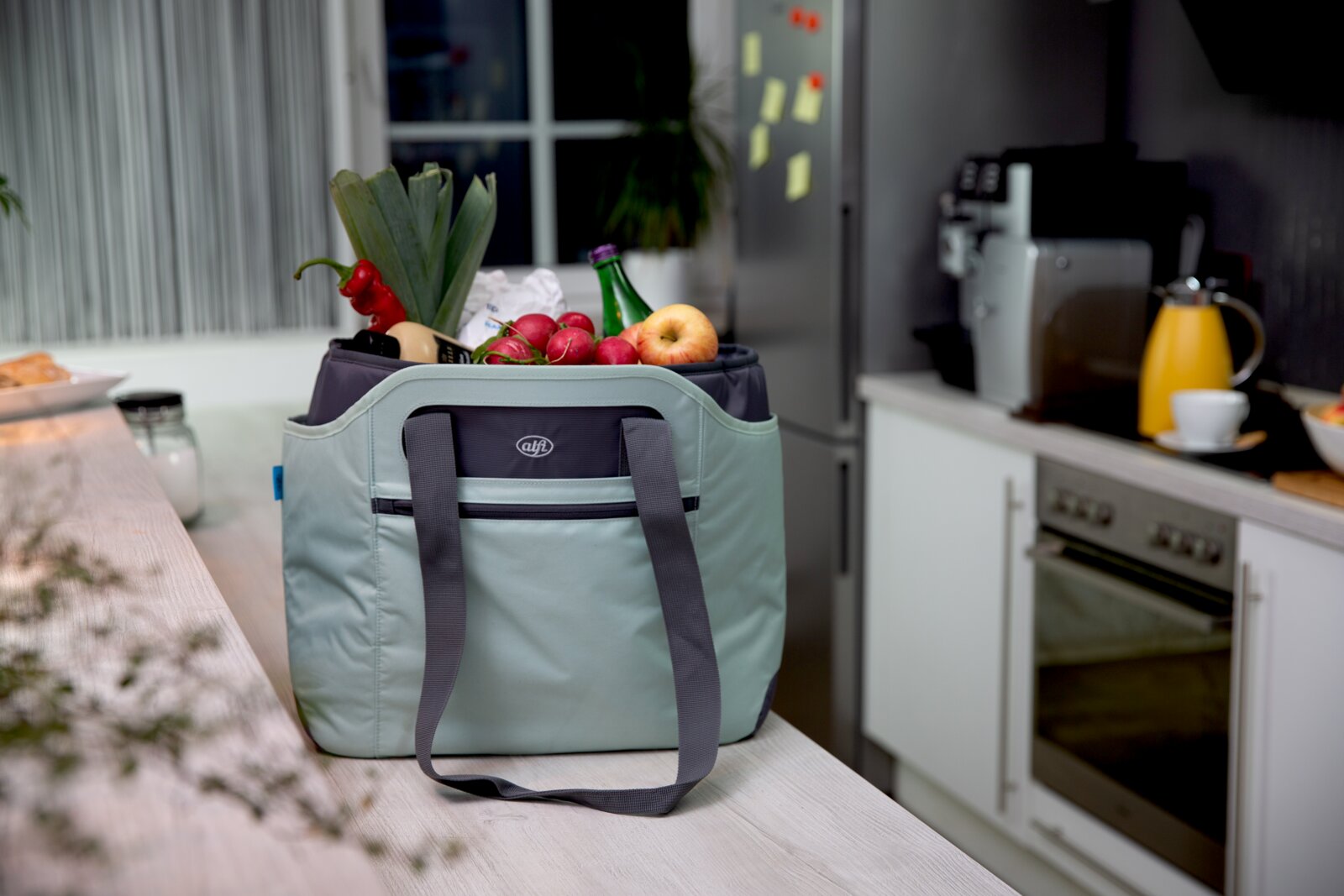 Iso Bag in einer Küche, gefüllt mit frischem Obst und Gemüse, aus einer seitlichen Perspektive fotografiert.