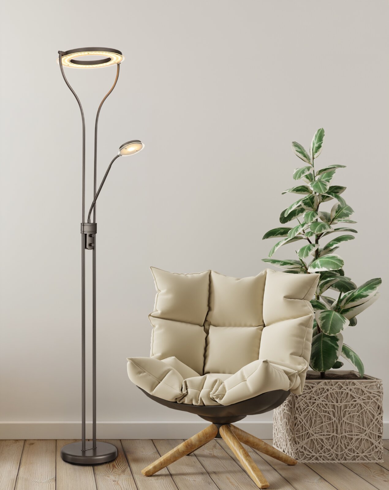Moderne LED-Bogen-Stehleuchte in Schwarz mit Ringlicht und zusätzlichem Lesearm, eingeschaltet, im Wohnzimmer neben beigem Lounge-Sessel und Zimmerpflanze, frontale Perspektive.