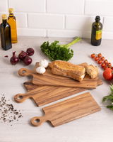 Holzgriffbrett in einer Küchenumgebung mit frischen Zutaten wie Brot, Knoblauch, Zwiebeln und Kräutern, von oben fotografiert.