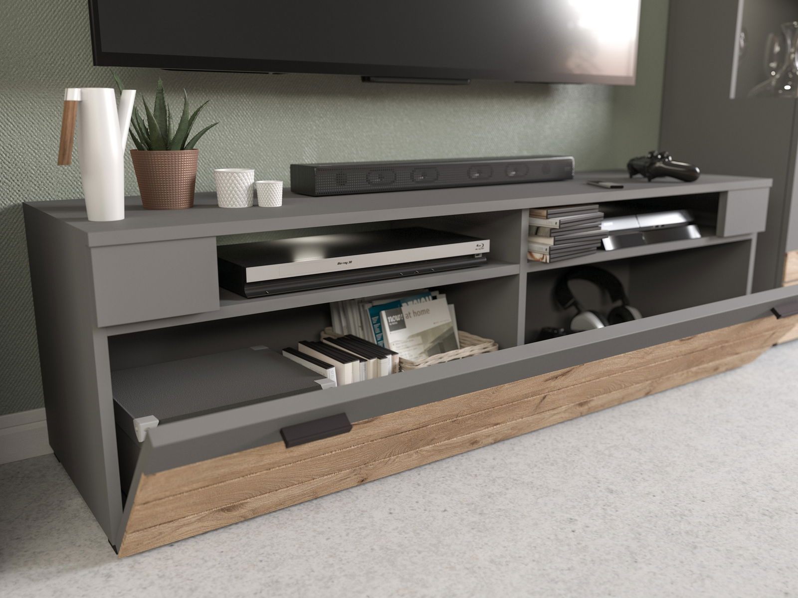 Modernes Lowboard in grauer Farbe mit Holzdetails, ausgestattet mit offenen Fächern und einer Klappe, von vorne betrachtet. Dekoriert mit Pflanzen und Elektronikgeräten.
