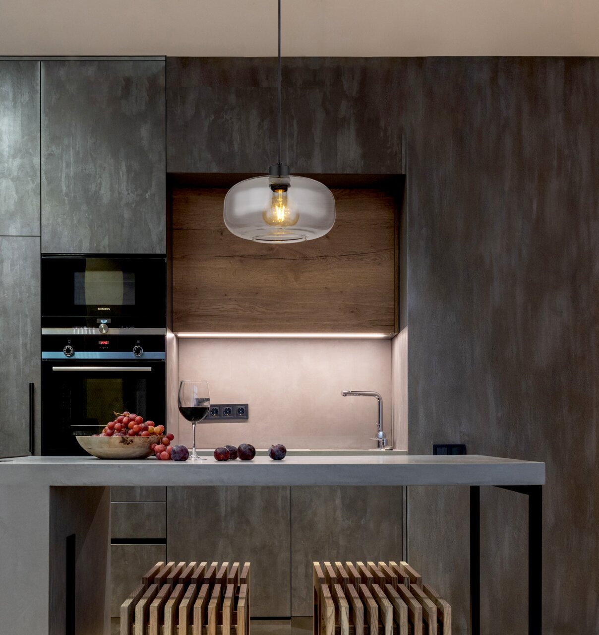 Moderne Hängeleuchte über einer Kücheninsel, seitliche Perspektive