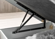 Nahaufnahme eines geöffneten Boxspringbetts mit hydraulischem Hebemechanismus, seitliche Perspektive.