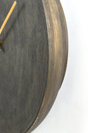 Nahaufnahme einer hölzernen Uhr mit seitlicher Perspektive, die die Textur und den Rand des Zifferblatts zeigt.