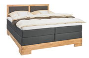 Boxspringbett mit Holzrahmen und grauem Stoffbezug, seitliche Perspektive