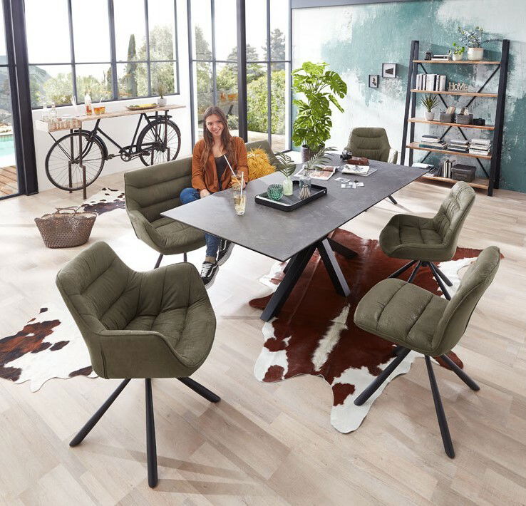 Esszimmer mit modernen, olivgrünen Stühlen und einem schwarzen Tisch, seitliche Perspektive